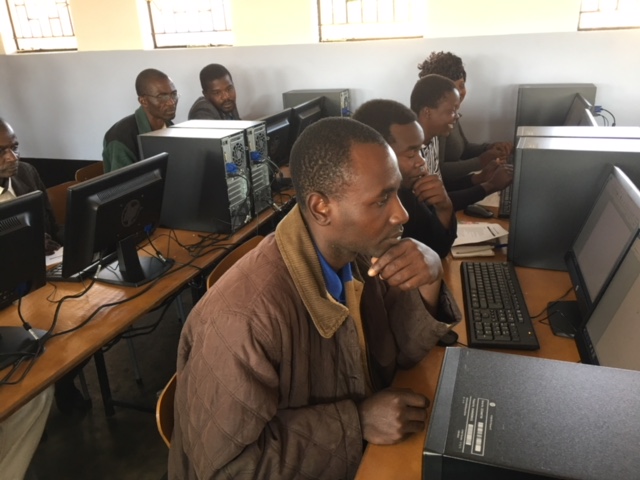 Een leraar krijgt computerles in Zimbabwe.
