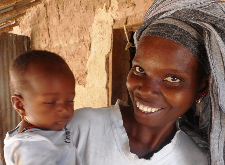 Drinkwater voor vier dorpen in Gambia, een lachende vrouw met een baby op haar arm