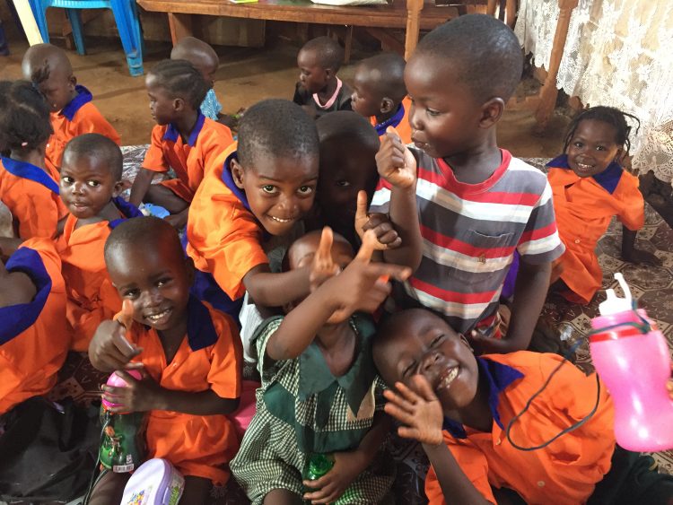 Een groepje vrolijke kinderen op school in Oeganda.