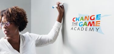 Een vrouw schrijft op een schoolbord tijdens een workshop.