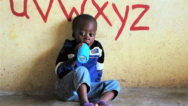 Een klein jongetje op school in Zambia.
