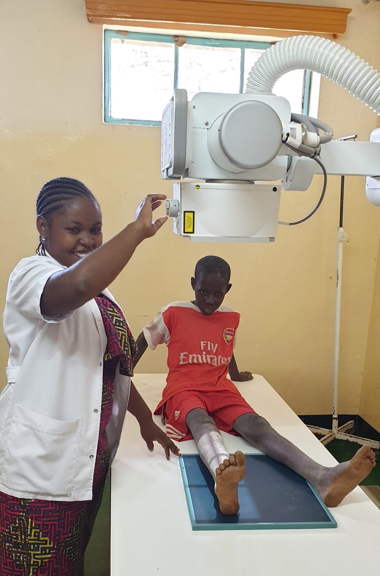 Een jongetje ligt met zijn been onder een rontgenapparaat in Tanzania.