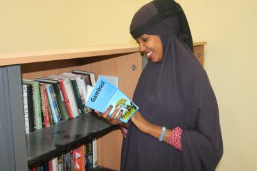 Een vrouw in Somalië kijkt een boek in.