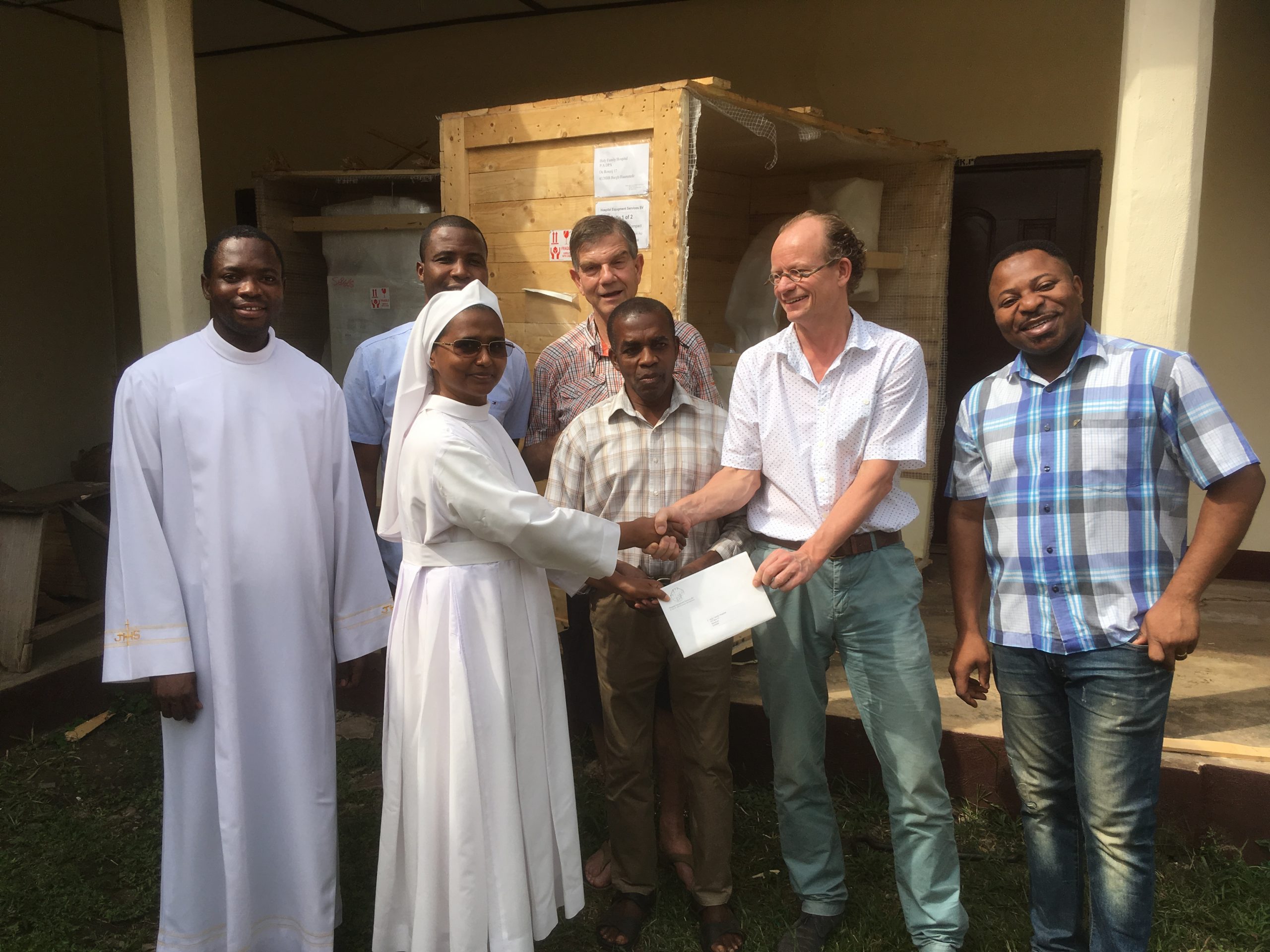 Een groep mensen poseert voor een gebouw na de opening.