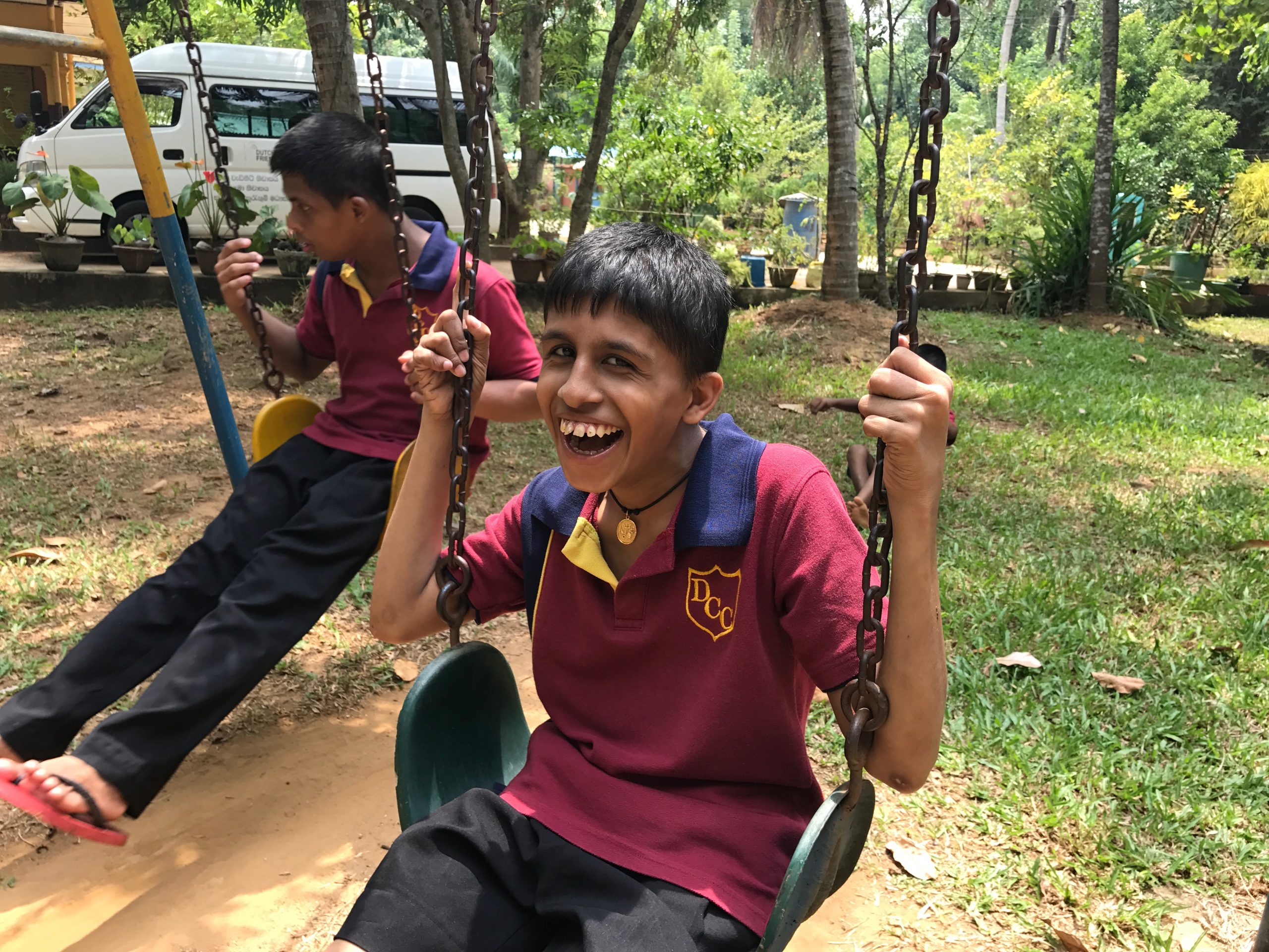Een jongen met een beperking zit op een schommel in Sri Lanka