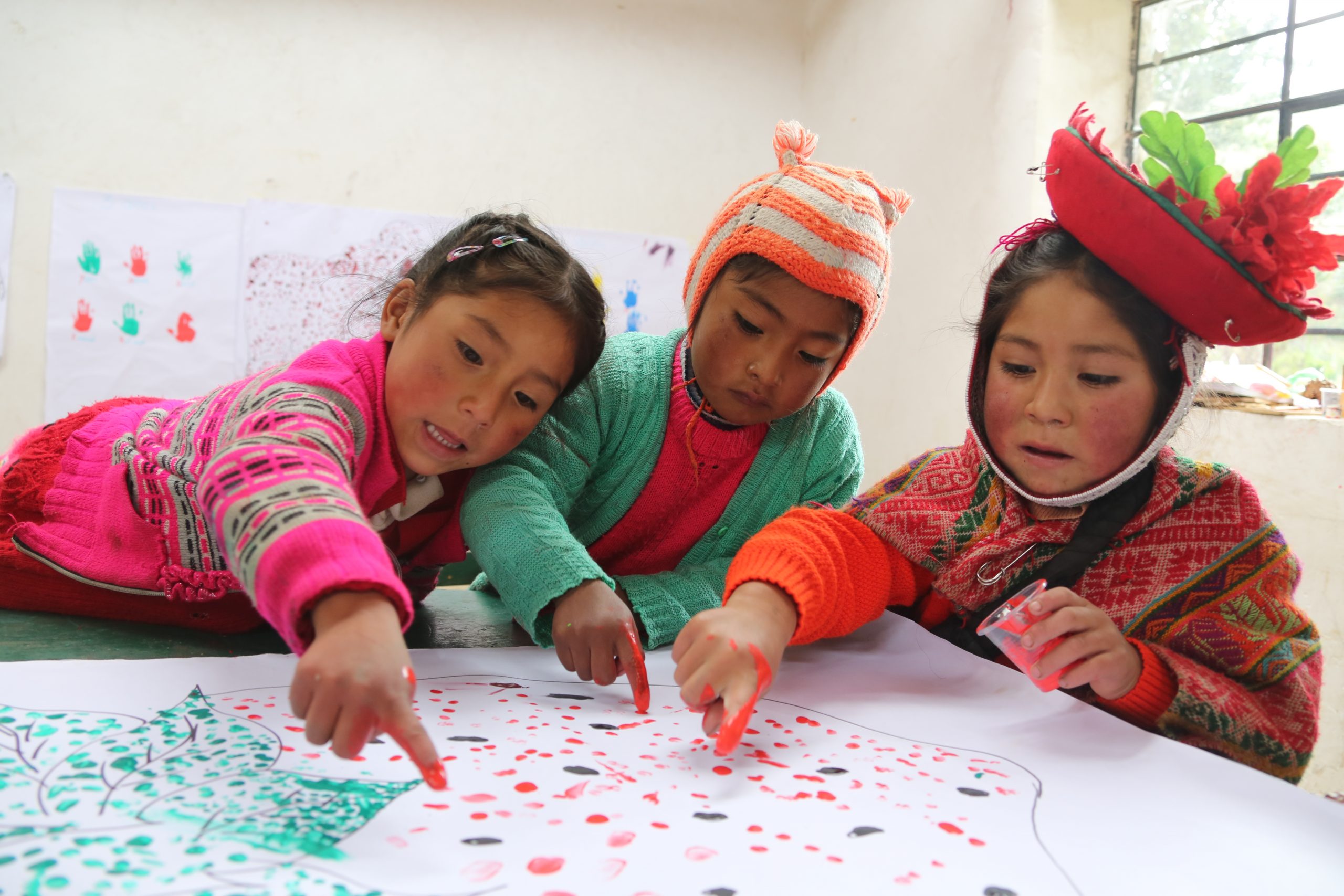Drie kleuters in hun klas in Peru.
