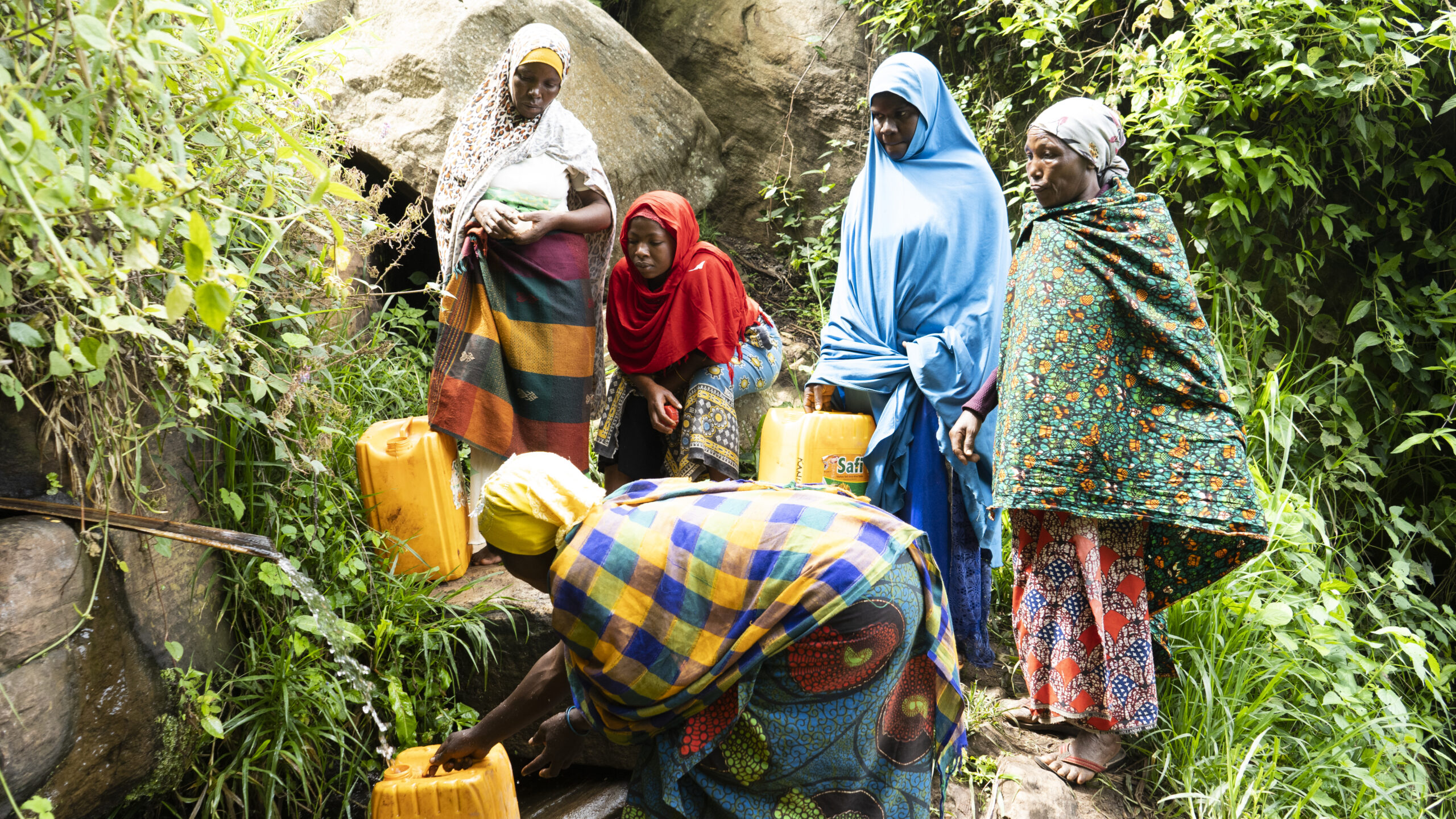 Vrouwen in Tanzania halen drinkwater met emmers.