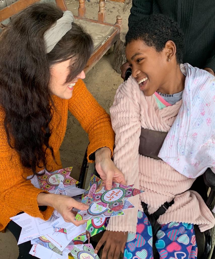 Ida overhandigt de kaarten aan een meisje met een beperking in Zuid Afrika.