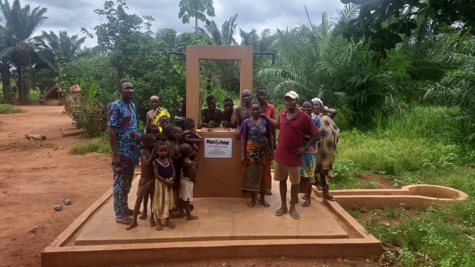 Een groep mensen bij een waterpomp