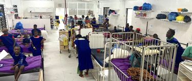 Een ziekenhuisafdeling met witte bedden en patienten